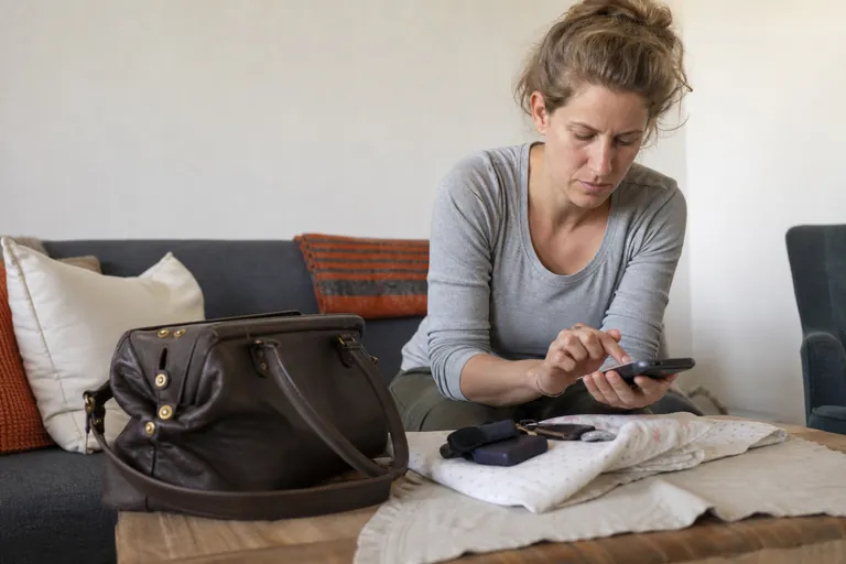 Hebamme prüft auf einem Smartphone eine Liste nach einem Hausbesuch